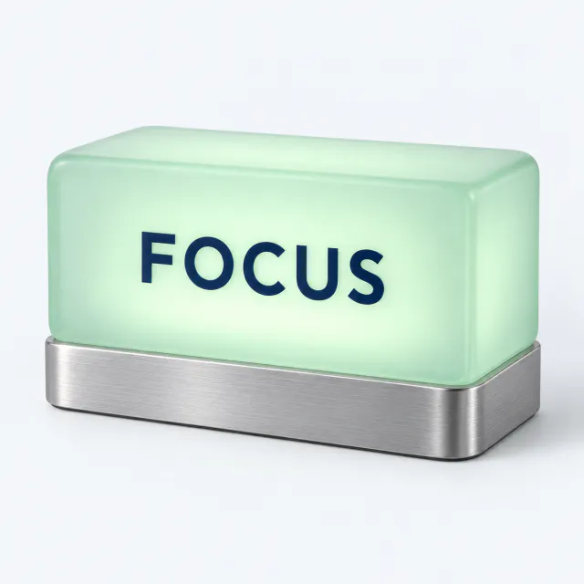 Frosted green desktop light bar marked Focus on a low brushed silver base