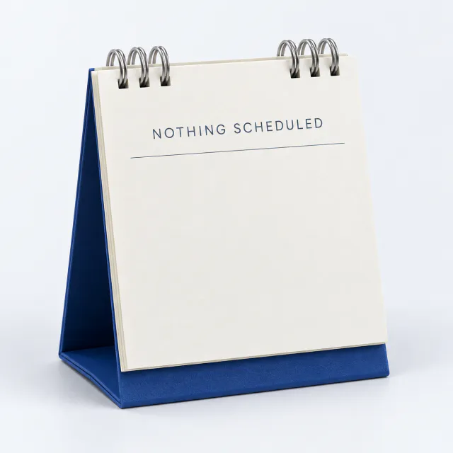 Minimal cream desk calendar with silver ring binding and an empty page labeled Nothing Scheduled